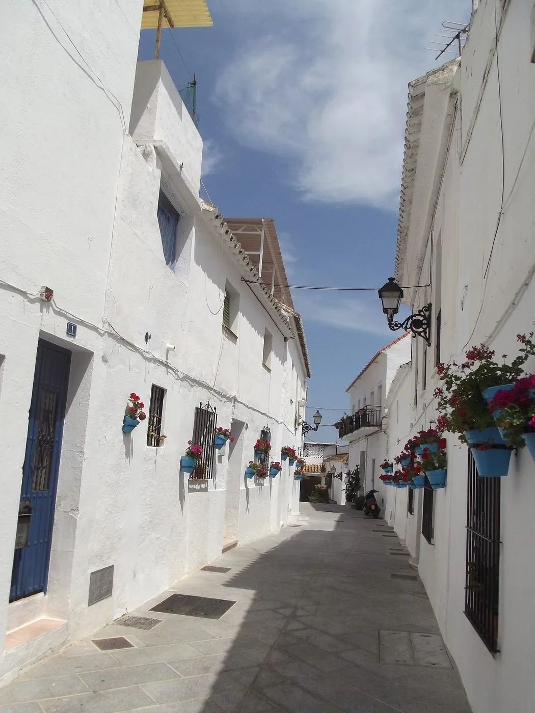 Witgekalkte muur met bloempotten in Mijas