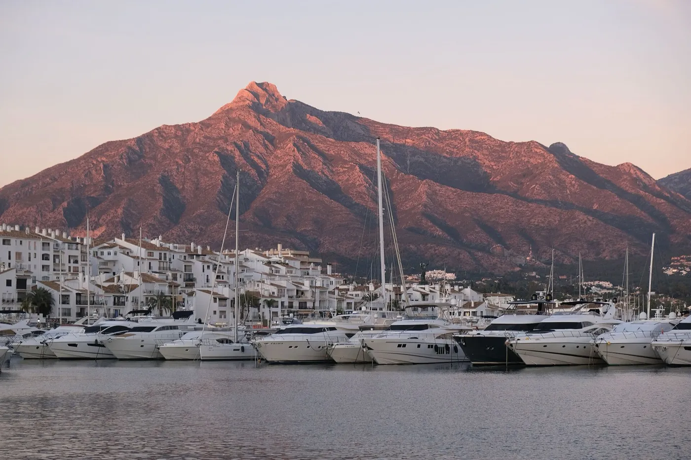 De jachthaven van Puerto Banús bij zonsondergang, met La Concha erachter